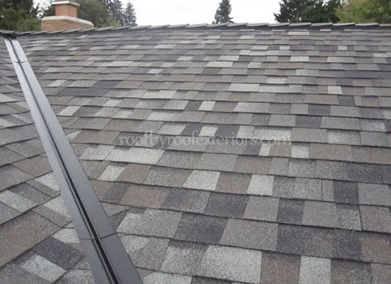 Close-up of a finished ridge and valley on a grey shingle roof